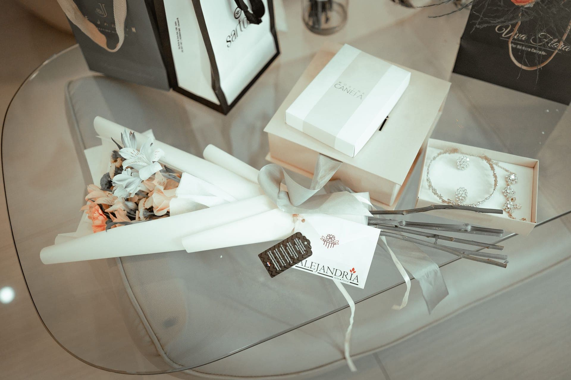 A small wrapped gift box beside a delicate chain necklace on linen