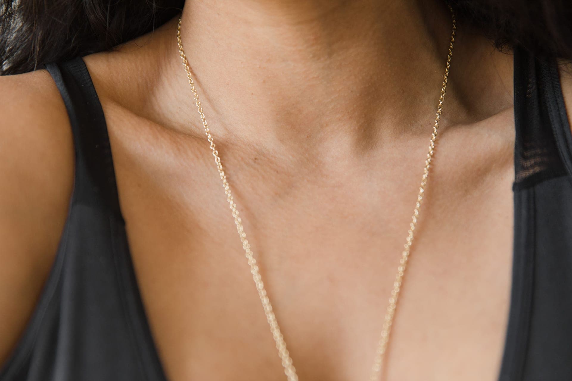 A gold-toned chain necklace displayed on linen