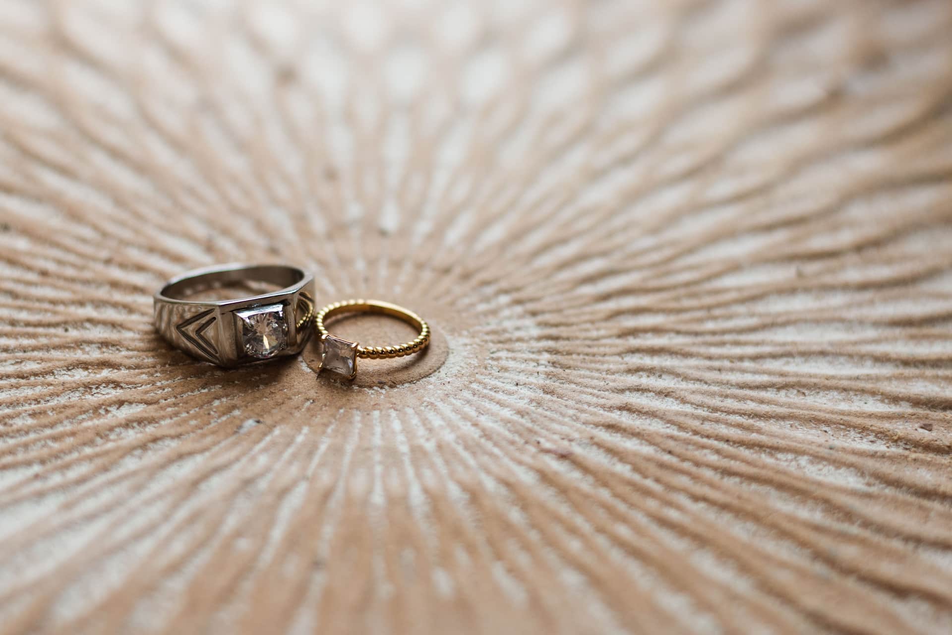 Gold-toned rings and bands arranged on a pale surface